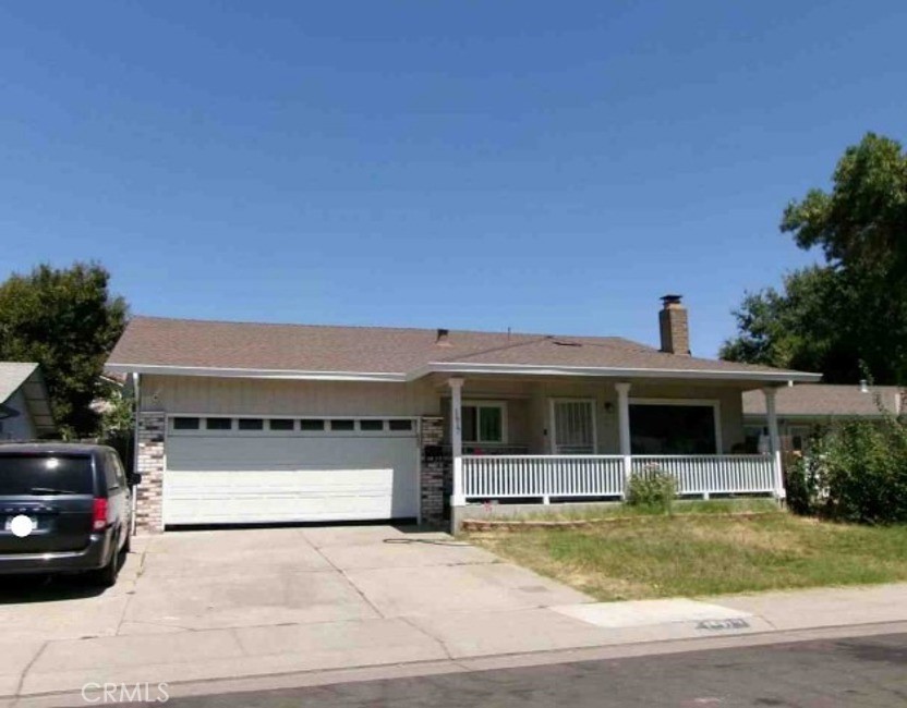 a view of a house with a garden and parking space