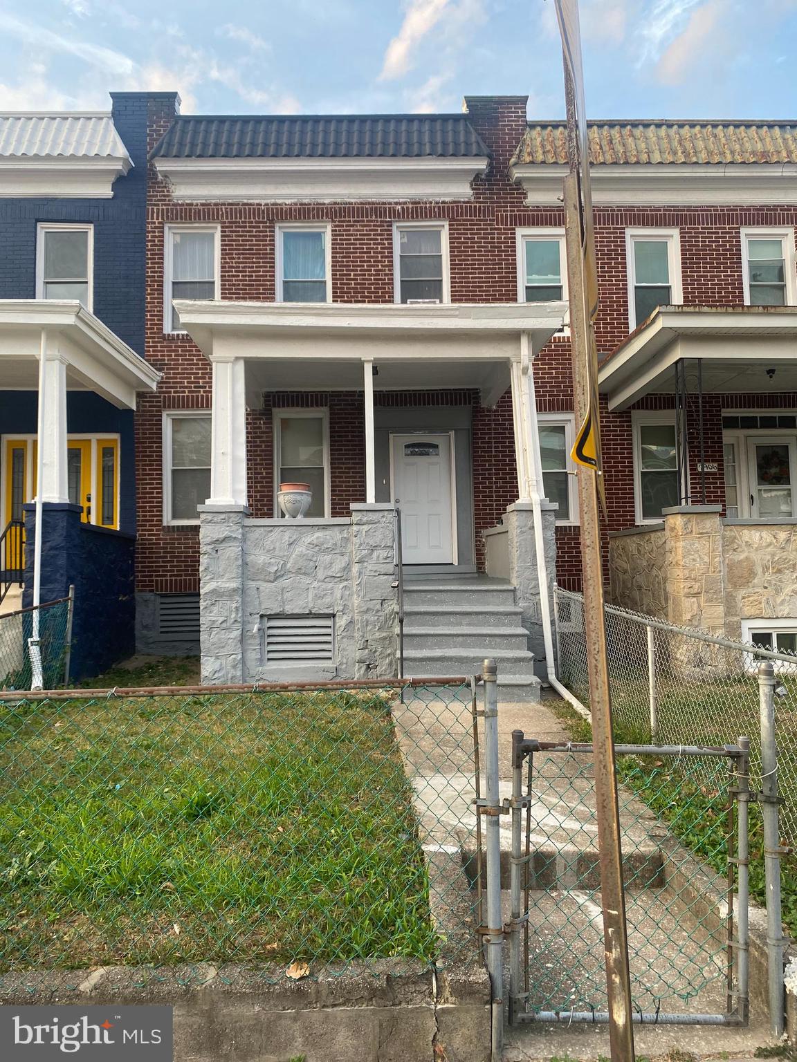 a view of front of a brick house with a yard