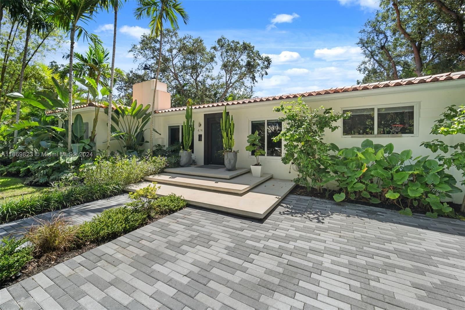 a front view of a house with a garden