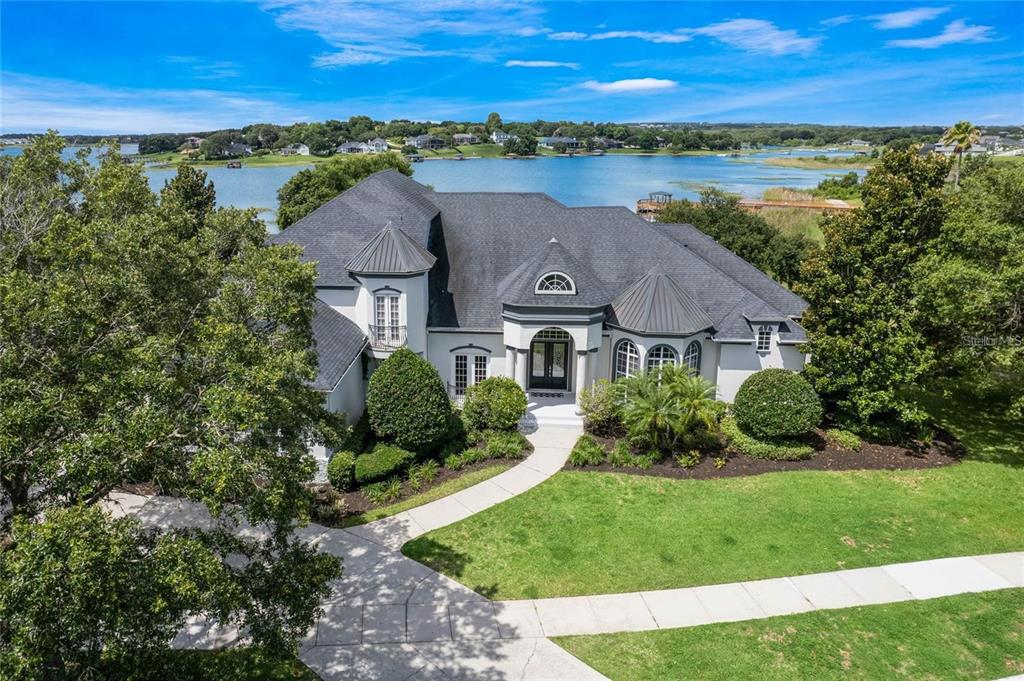 an aerial view of a house with a garden and lake view