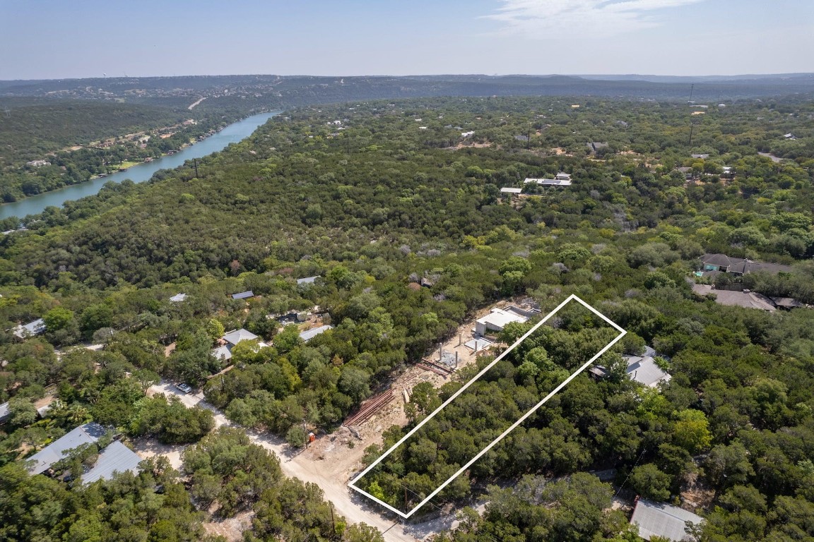 an aerial view of residential houses with outdoor space and trees