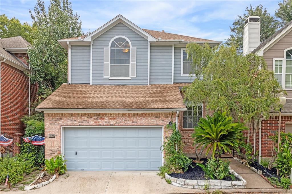 a front view of a house with a garden and garage