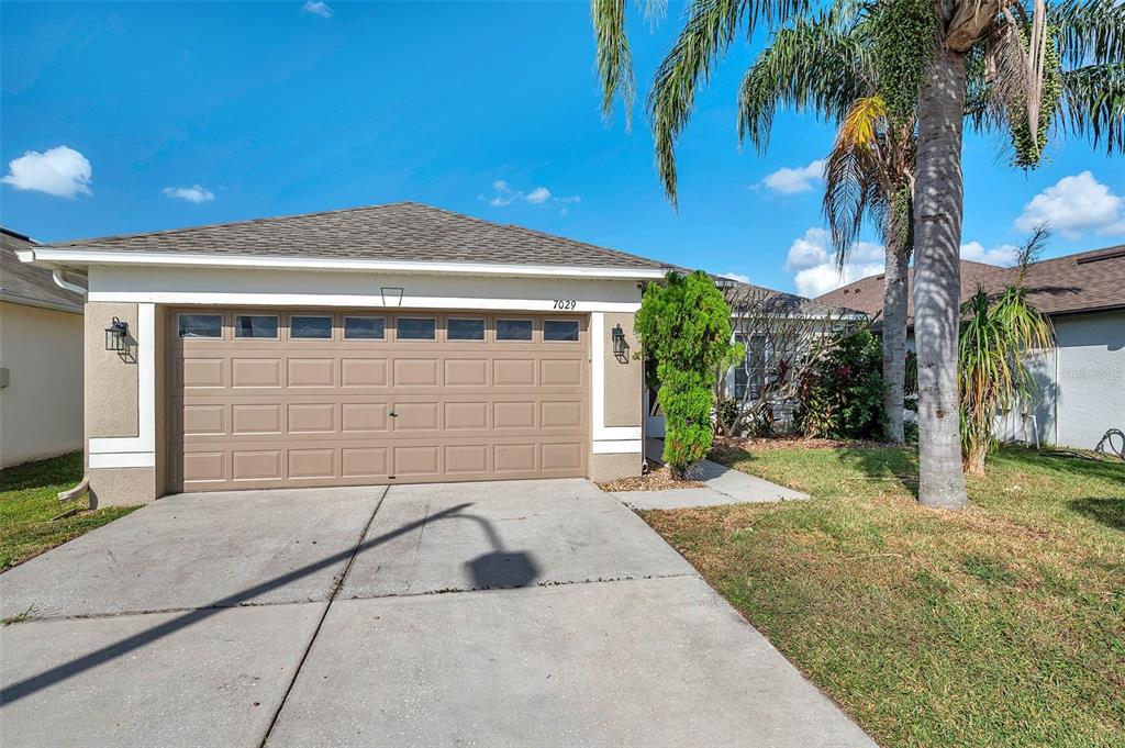 a front view of a house with a yard and garage