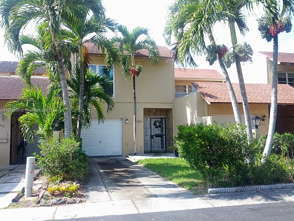 a front view of a house with yard and trees