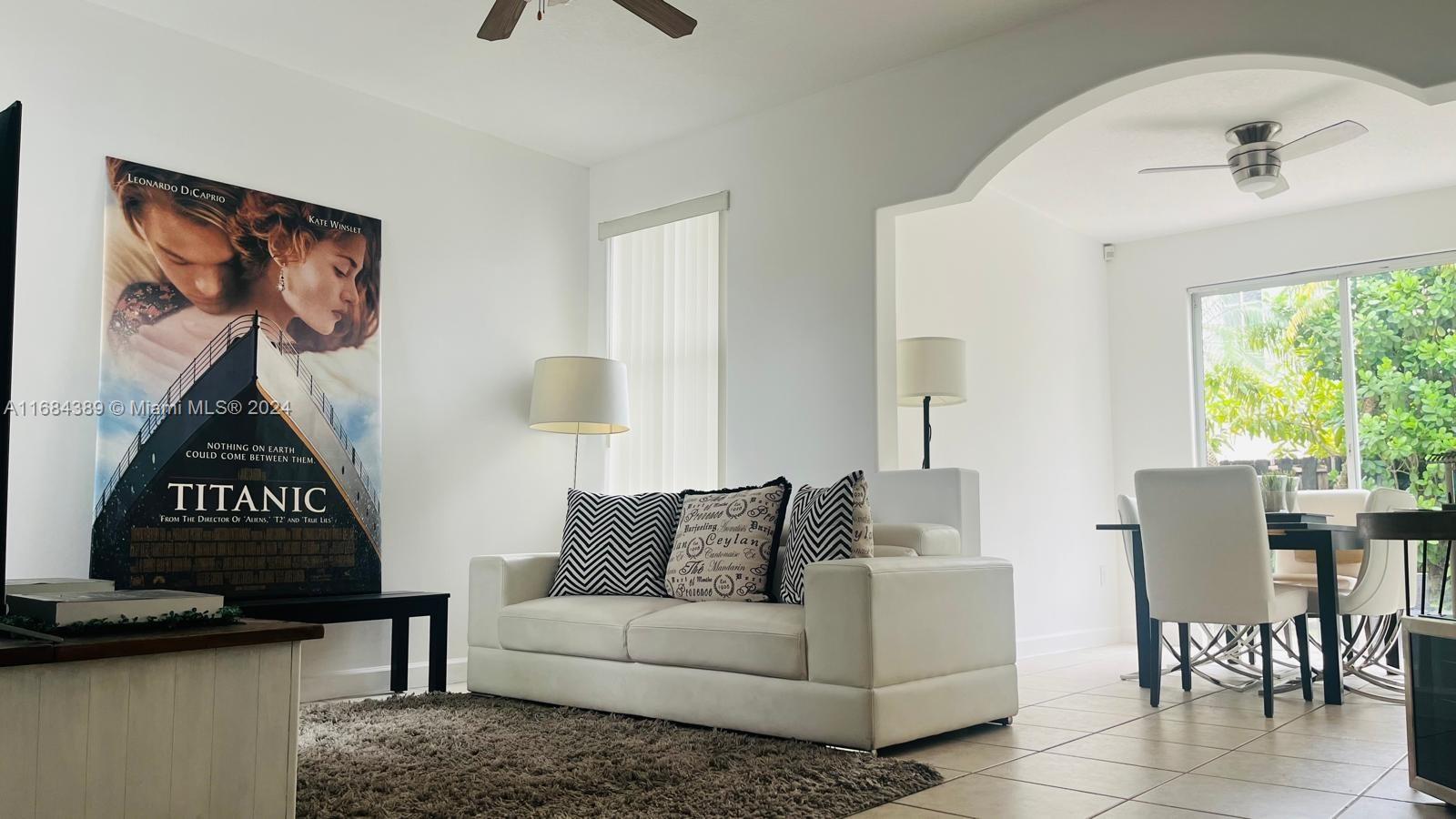 a living room with furniture a window and a flat screen tv