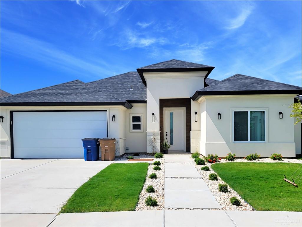 View of front of house with a garage and a front lawn