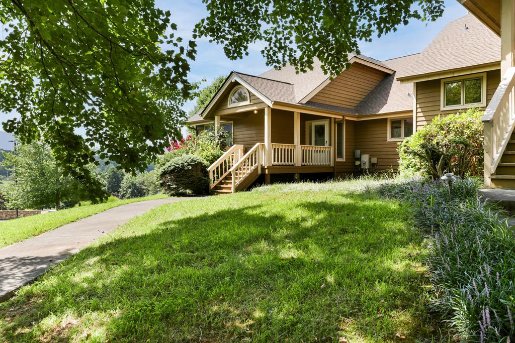 a front view of a house with a yard and trees