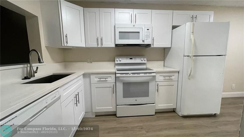 a kitchen with cabinets appliances and a sink