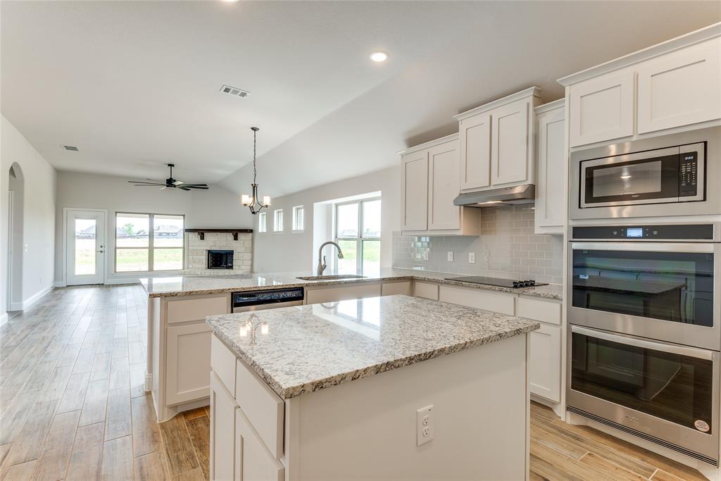 a kitchen with stainless steel appliances granite countertop a stove microwave and cabinets