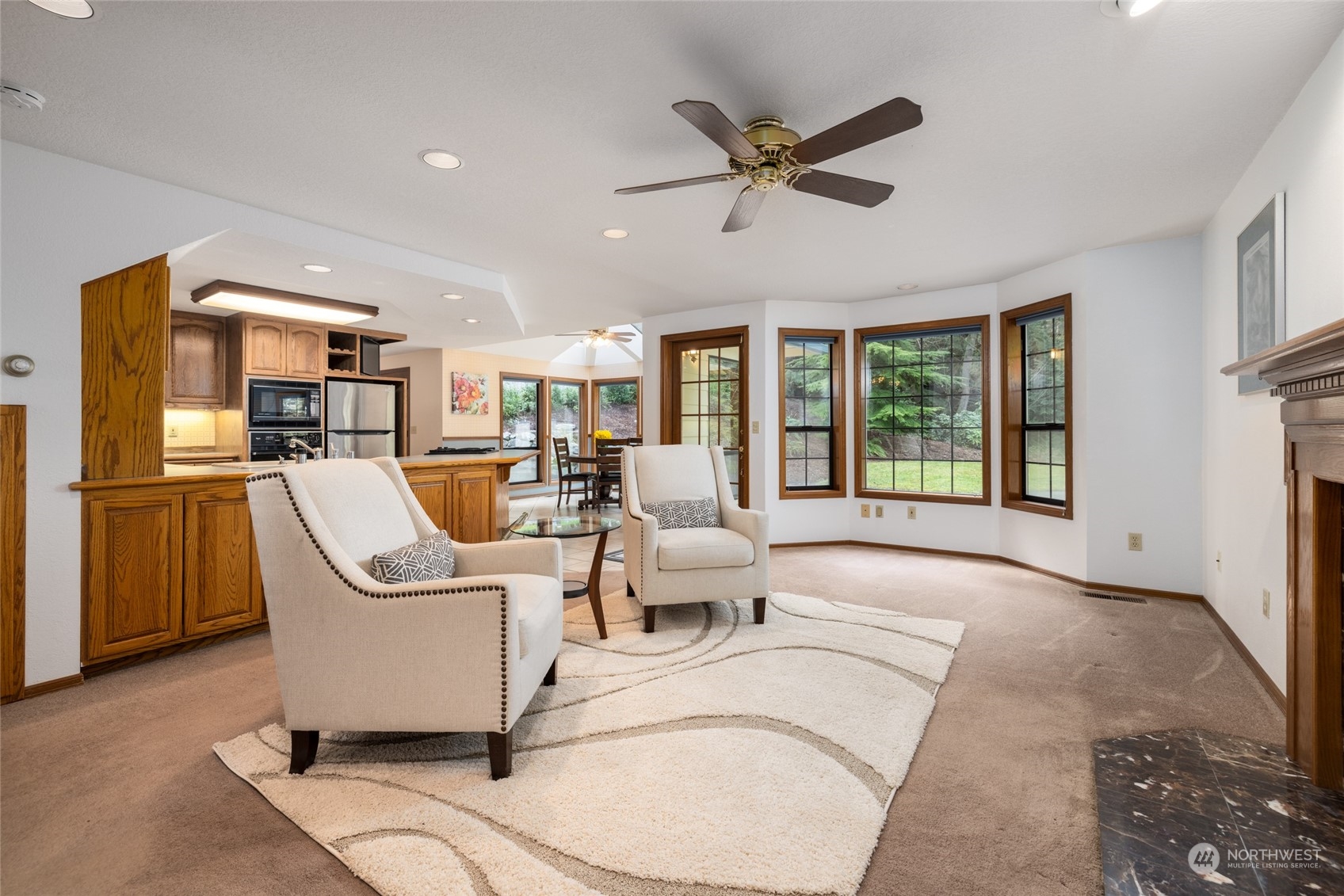 a living room with couches a flat tv screen and a dining table with wooden floor