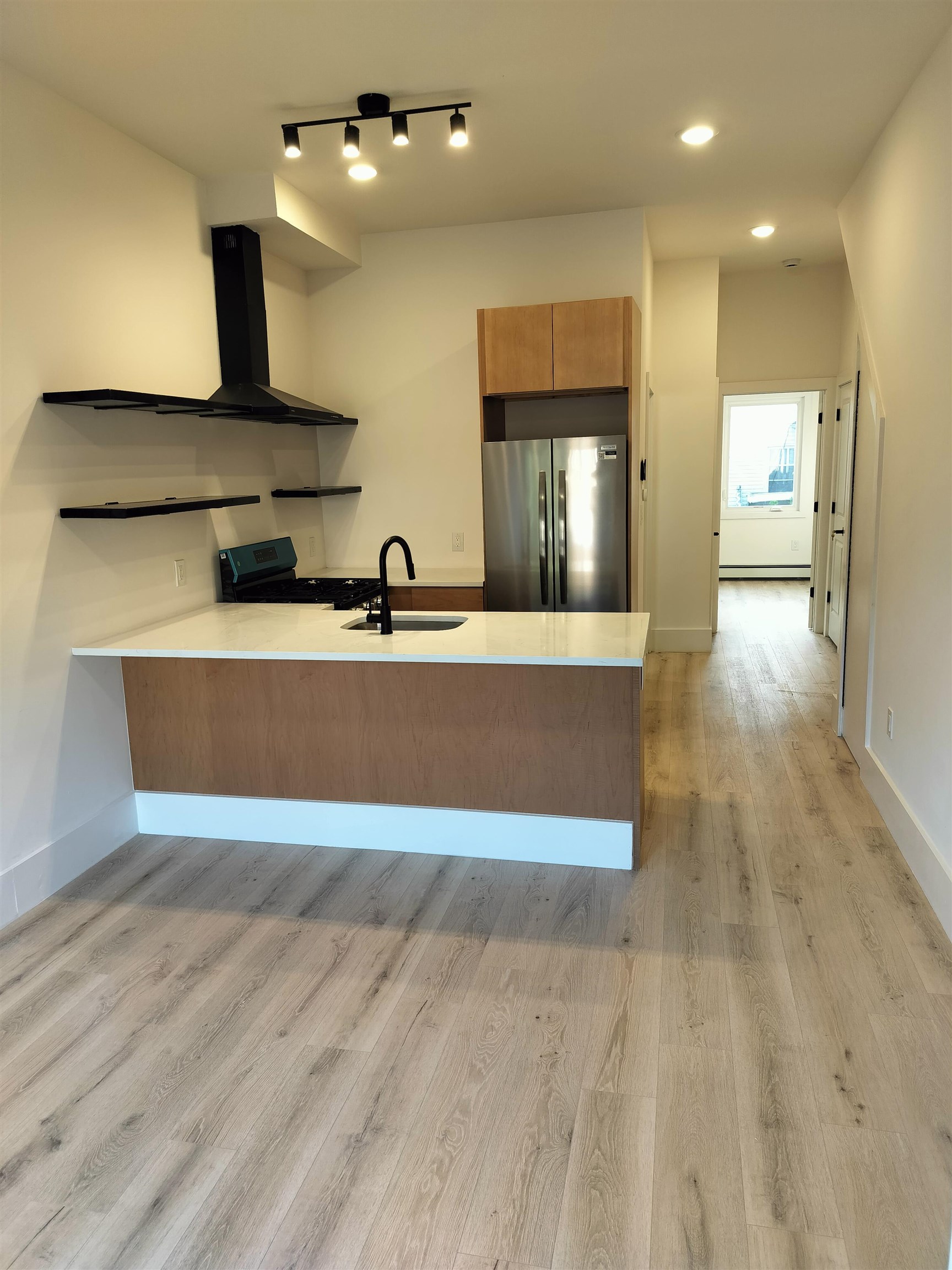 a view of a kitchen with a sink and a refrigerator