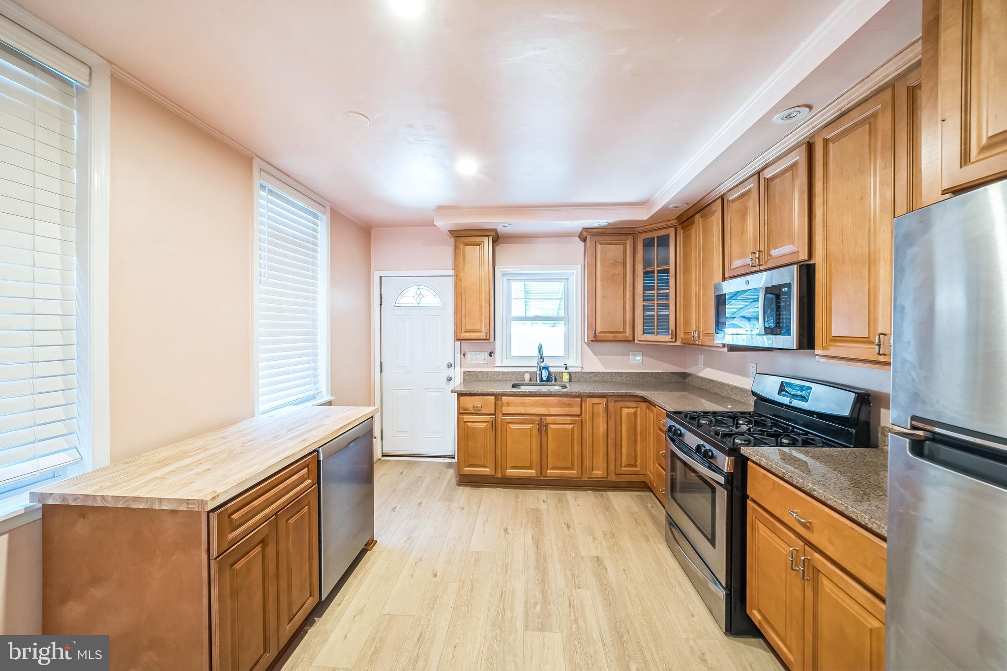 a kitchen with stainless steel appliances granite countertop a stove a sink dishwasher and a refrigerator