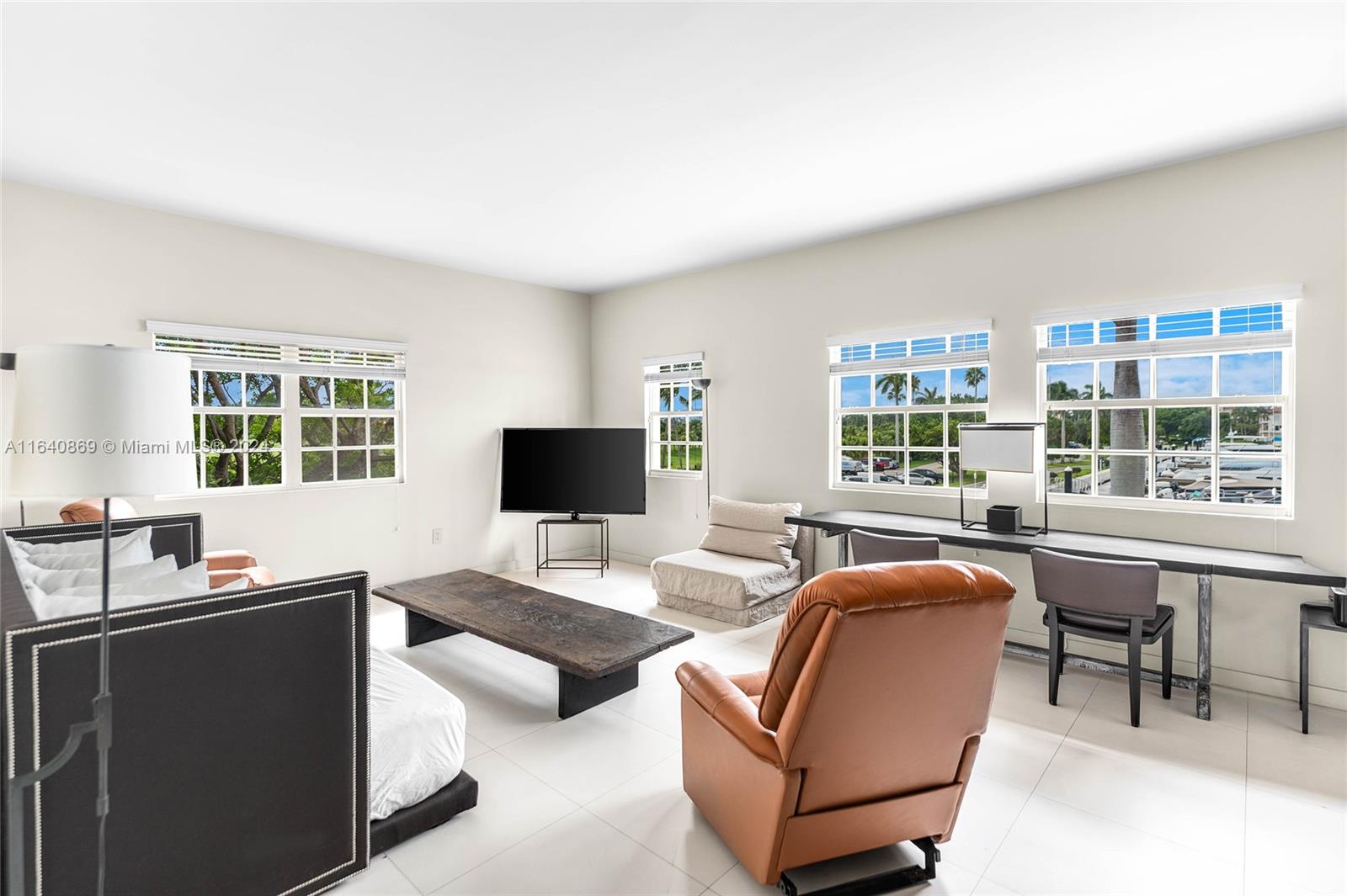 a living room with furniture a flat screen tv and a large window