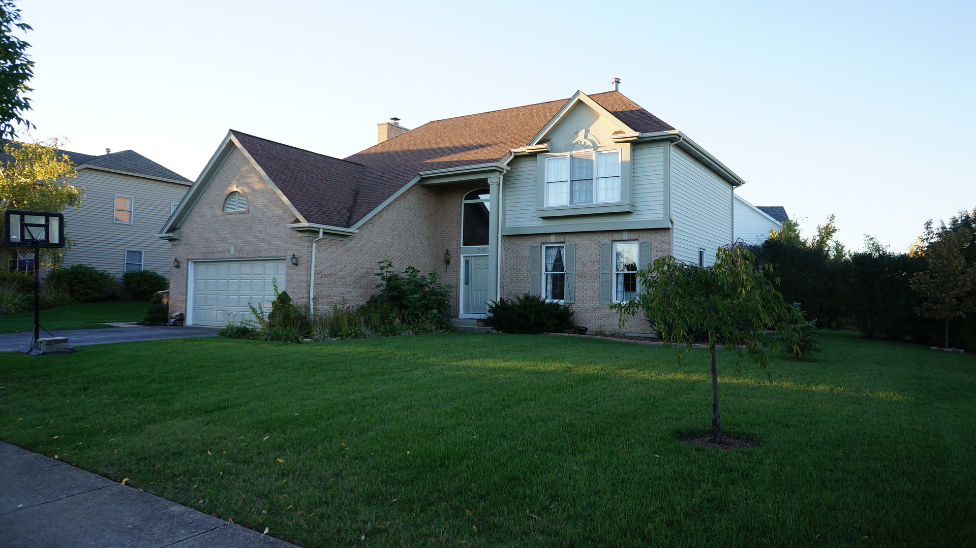 a front view of a house with a yard and trees