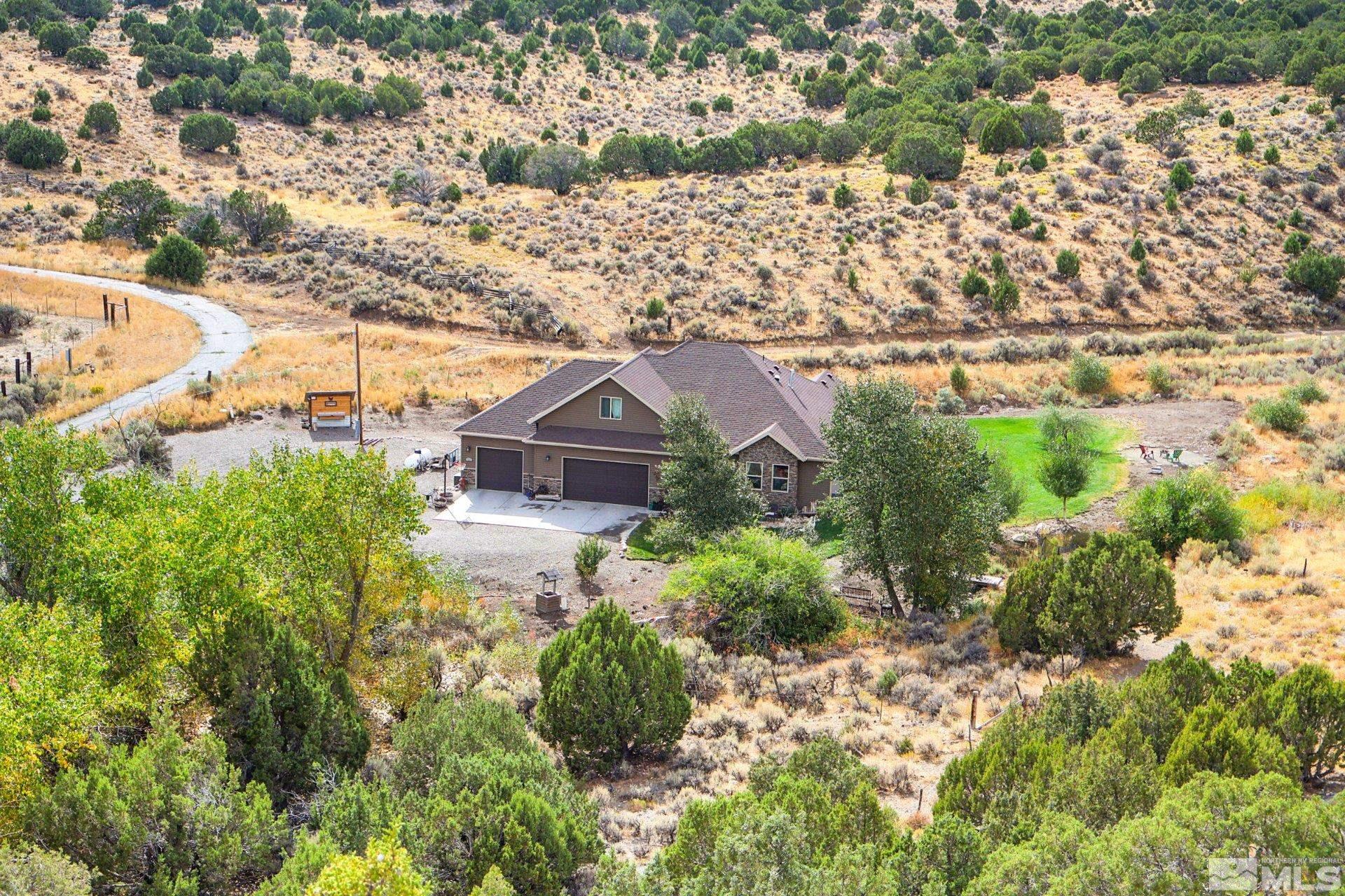 an aerial view of a house with a yard and lake view