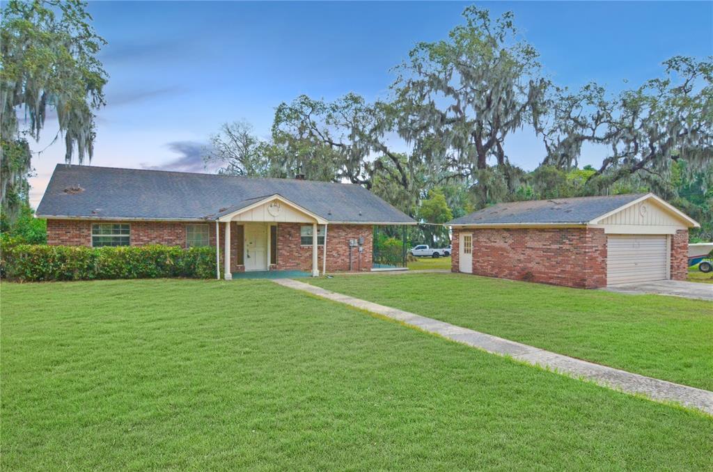 a front view of a house with a yard and trees