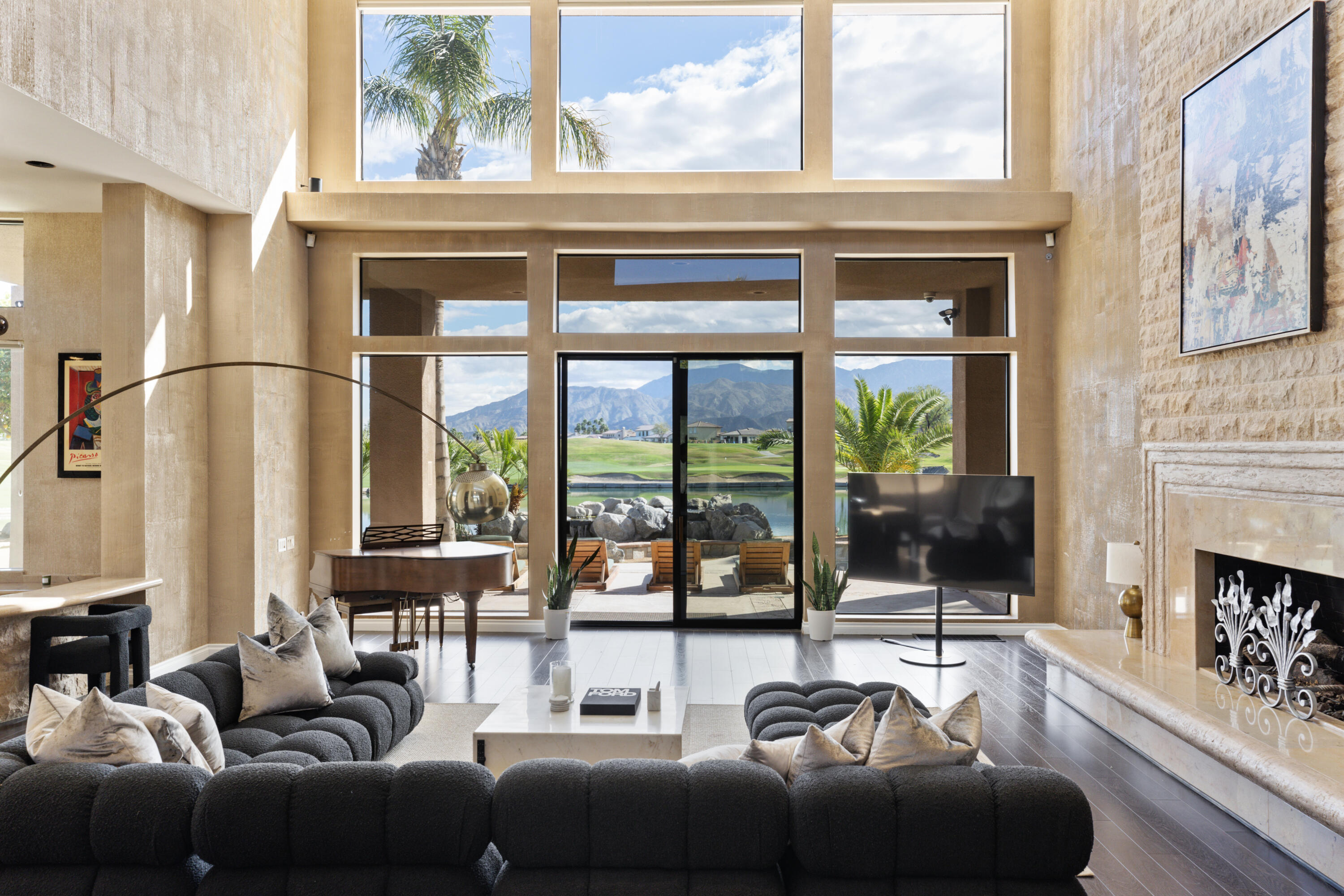 a living room with furniture a fireplace and a floor to ceiling window