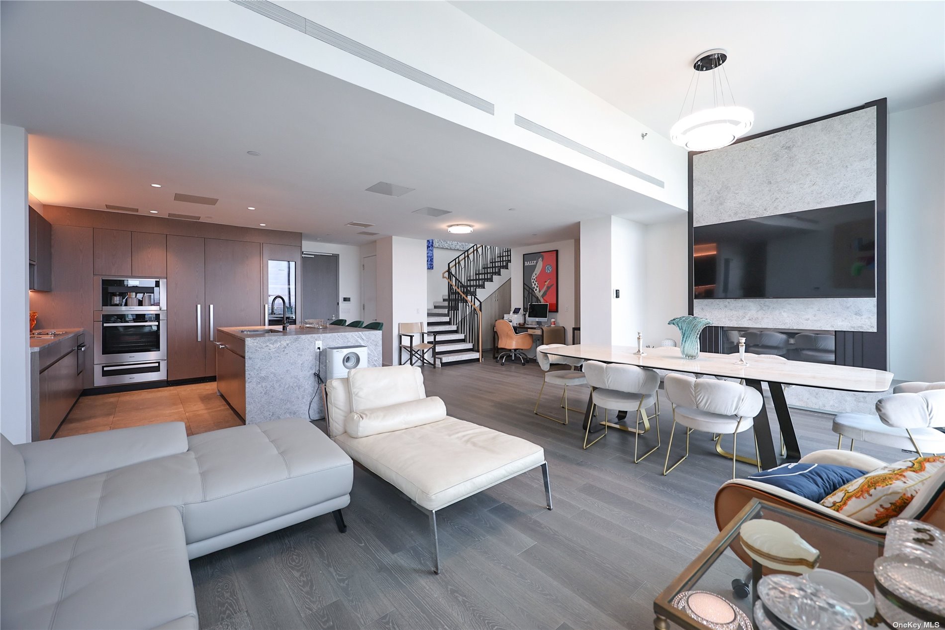 a living room with furniture kitchen view and a flat screen tv