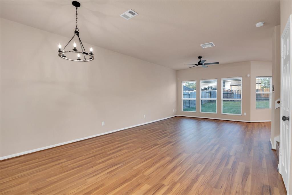 a view of a room with wooden floor air conditioner and windows