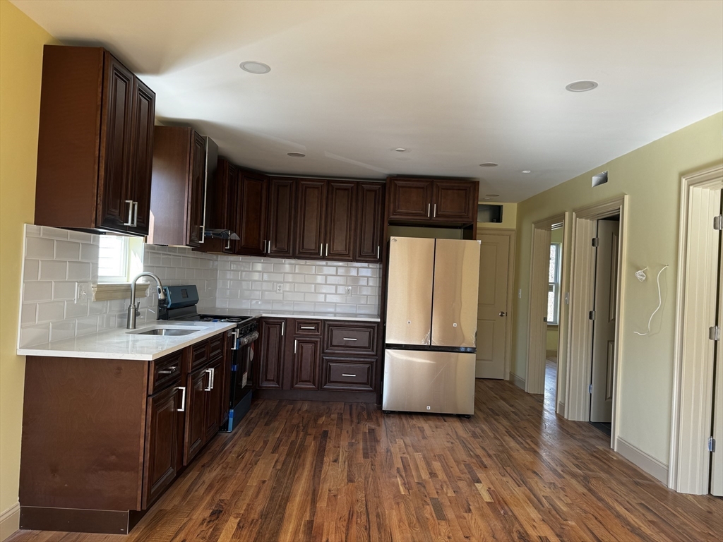 a kitchen with a refrigerator a sink and wooden cabinets