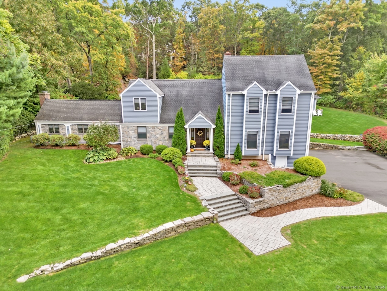 a aerial view of a house with a big yard potted plants and a large tree