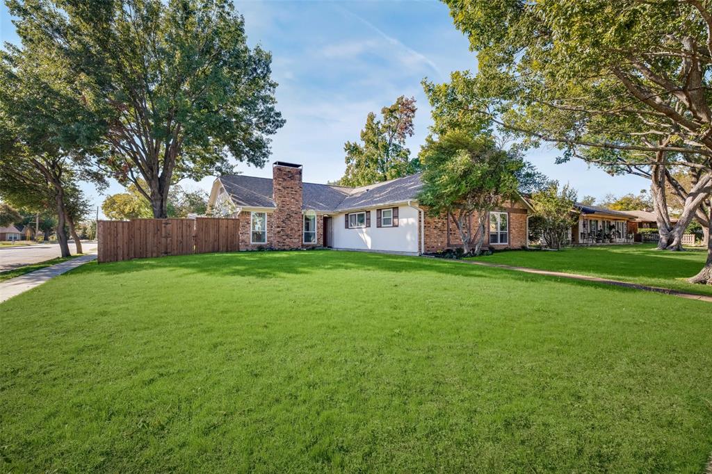 a view of a house with a big yard with large tree