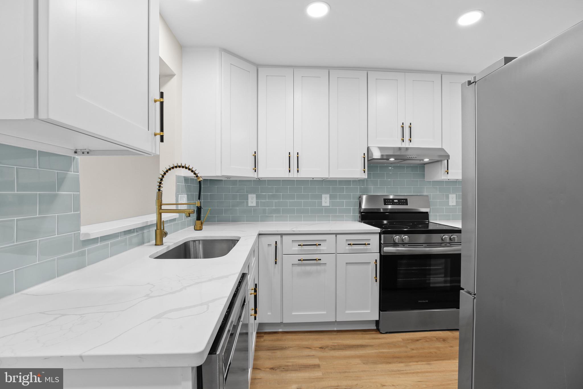 a kitchen with white cabinets and appliances