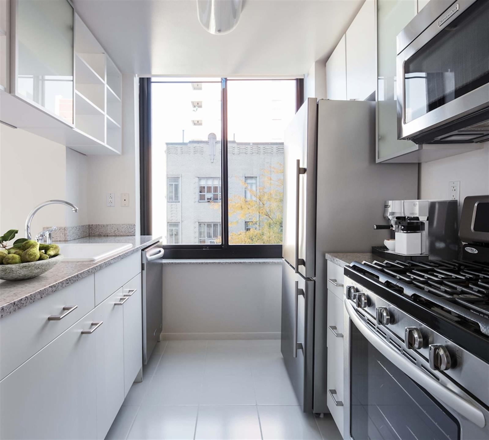 a kitchen with stainless steel appliances a refrigerator a sink and white cabinets