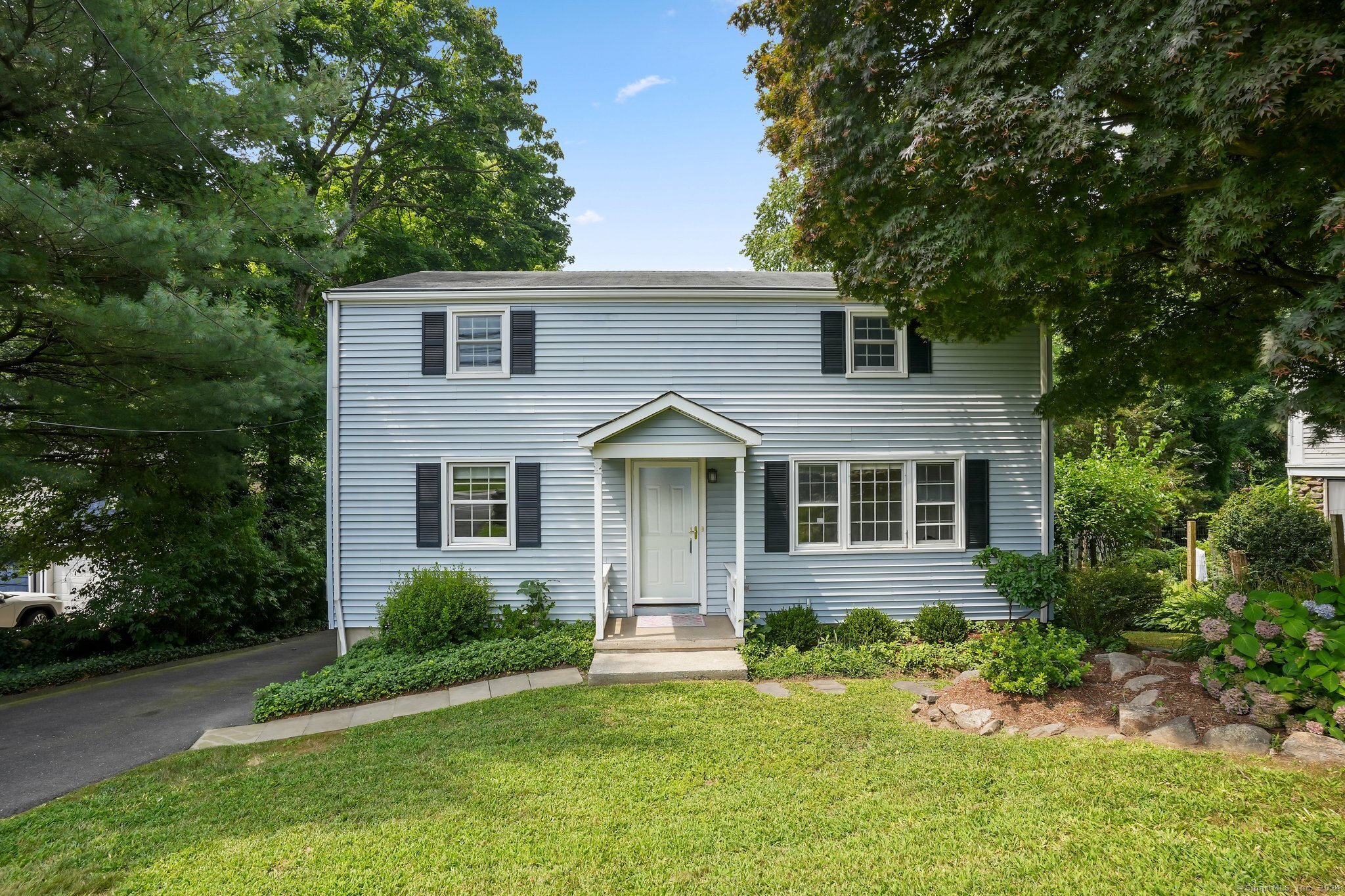 a front view of a house with a yard and trees