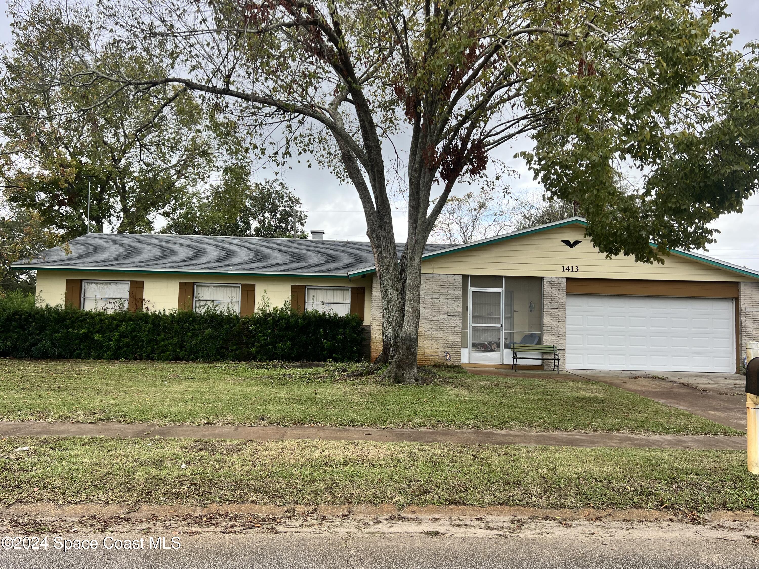 a front view of a house with yard and green space