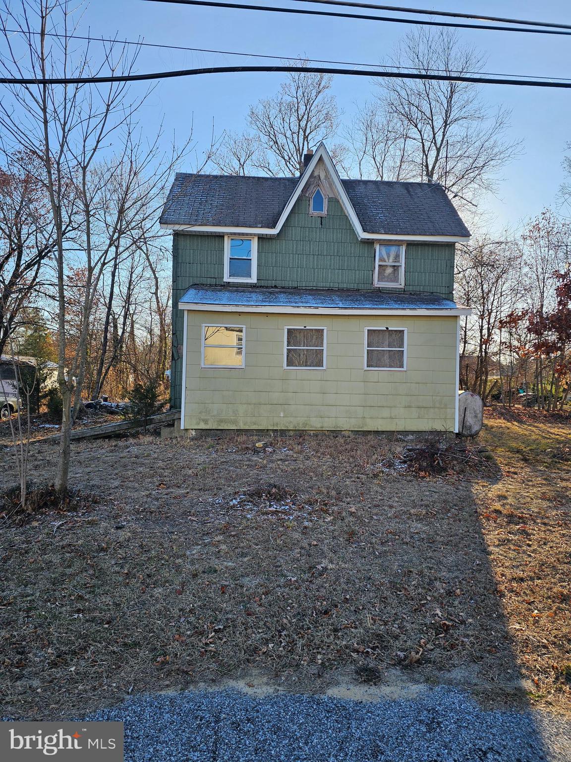 a view of a white house next to a yard