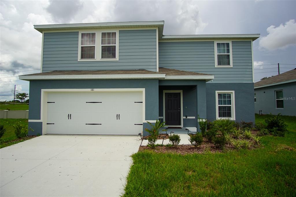 a front view of a house with a yard and garage