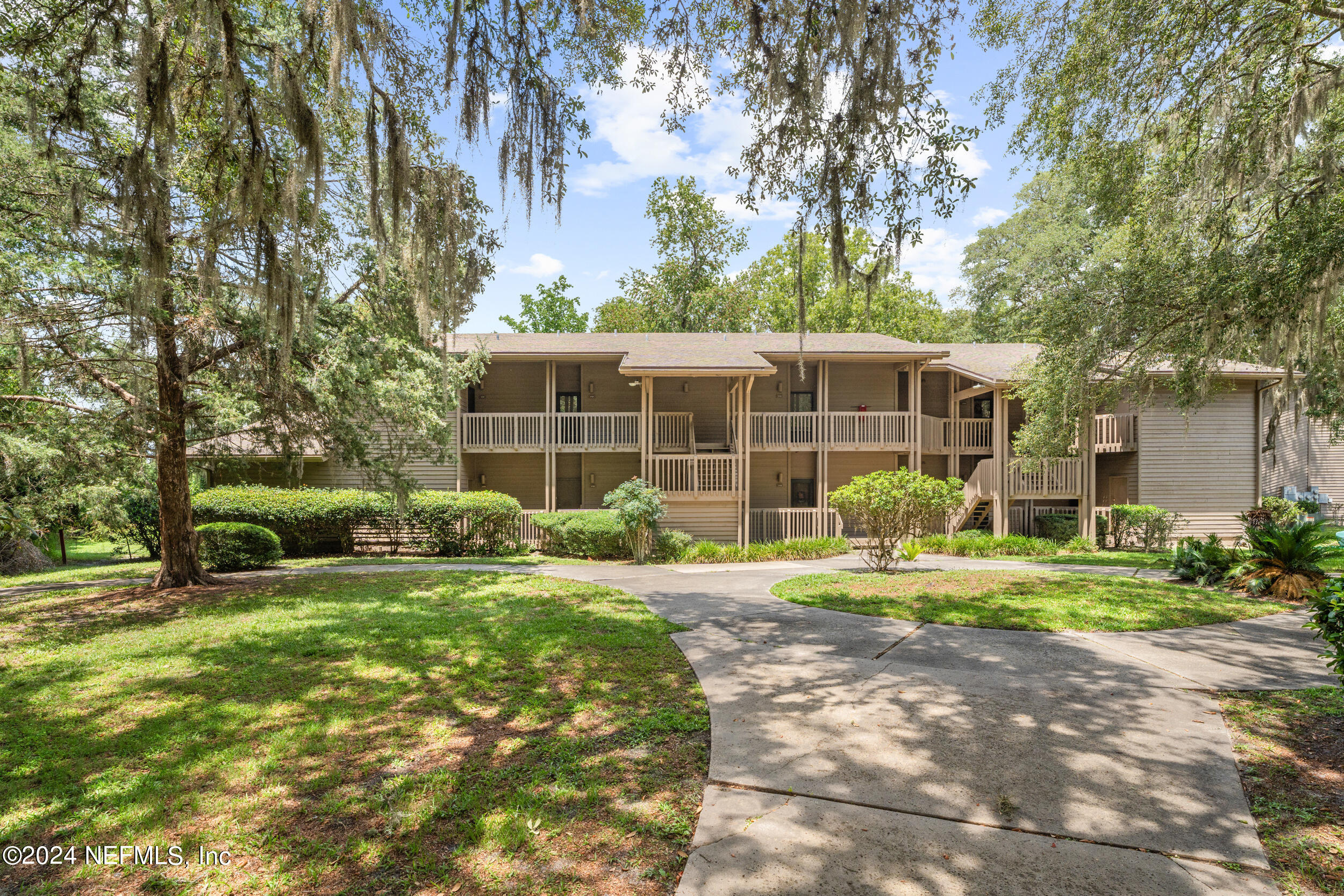 a front view of a house with a yard and trees