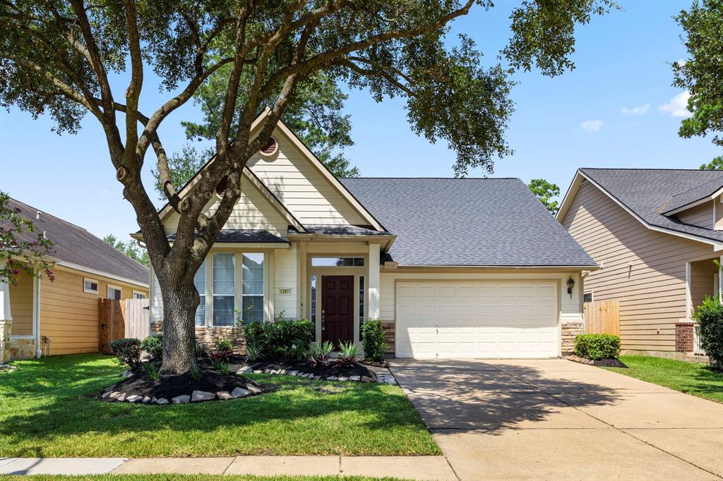 a front view of a house with a yard and trees