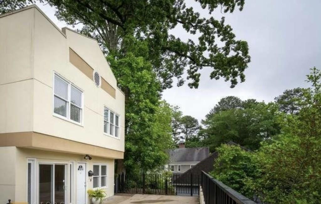 a view of a white house next to a tree