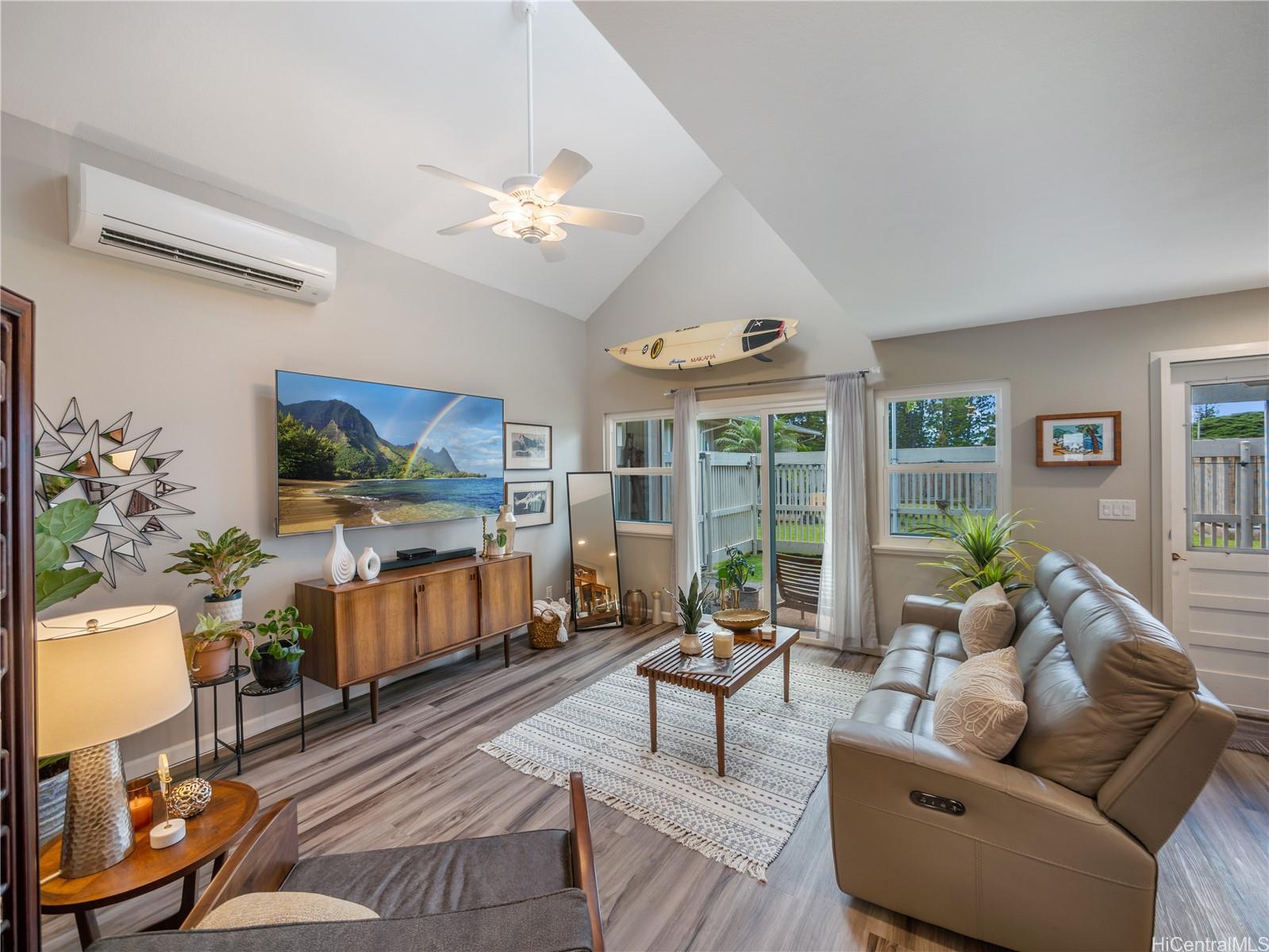 a living room with furniture a flat screen tv and a large window