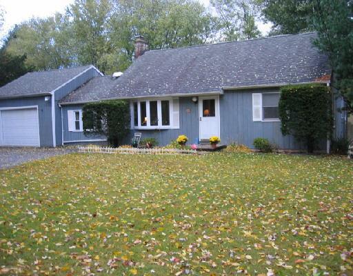 a front view of a house with yard and trees