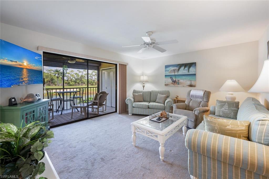 a living room with furniture a chandelier and a large window