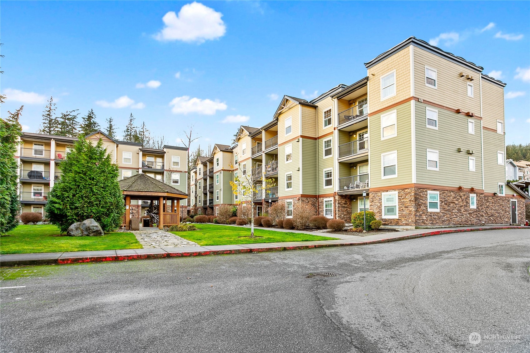 a front view of multi story residential apartment building with yard and traffic signal