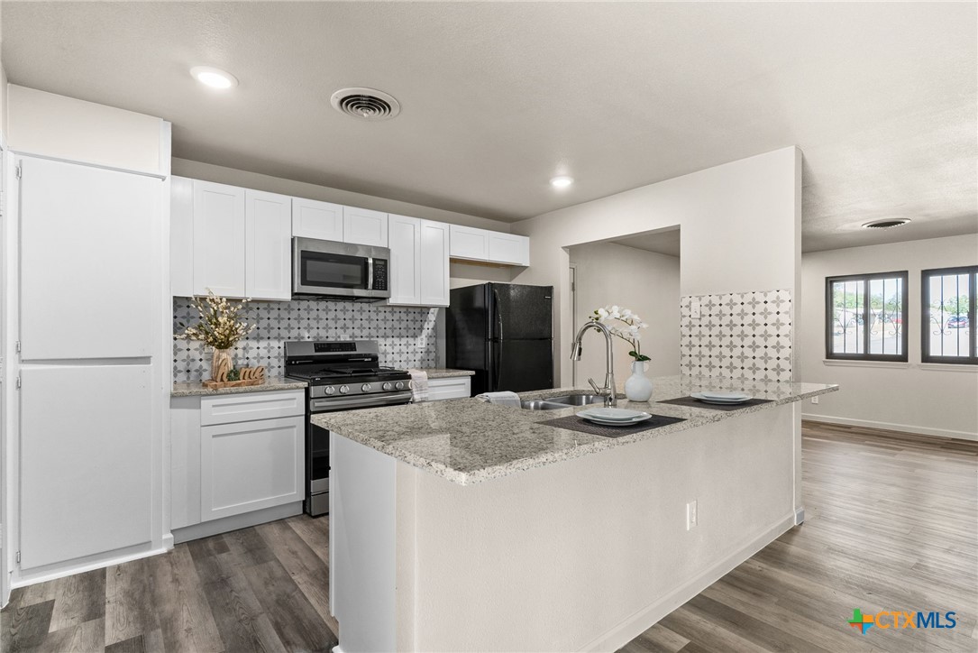 a kitchen with sink a microwave and refrigerator