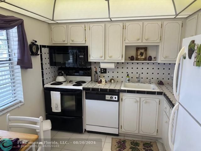 a kitchen with stainless steel appliances a sink a stove a microwave and cabinets