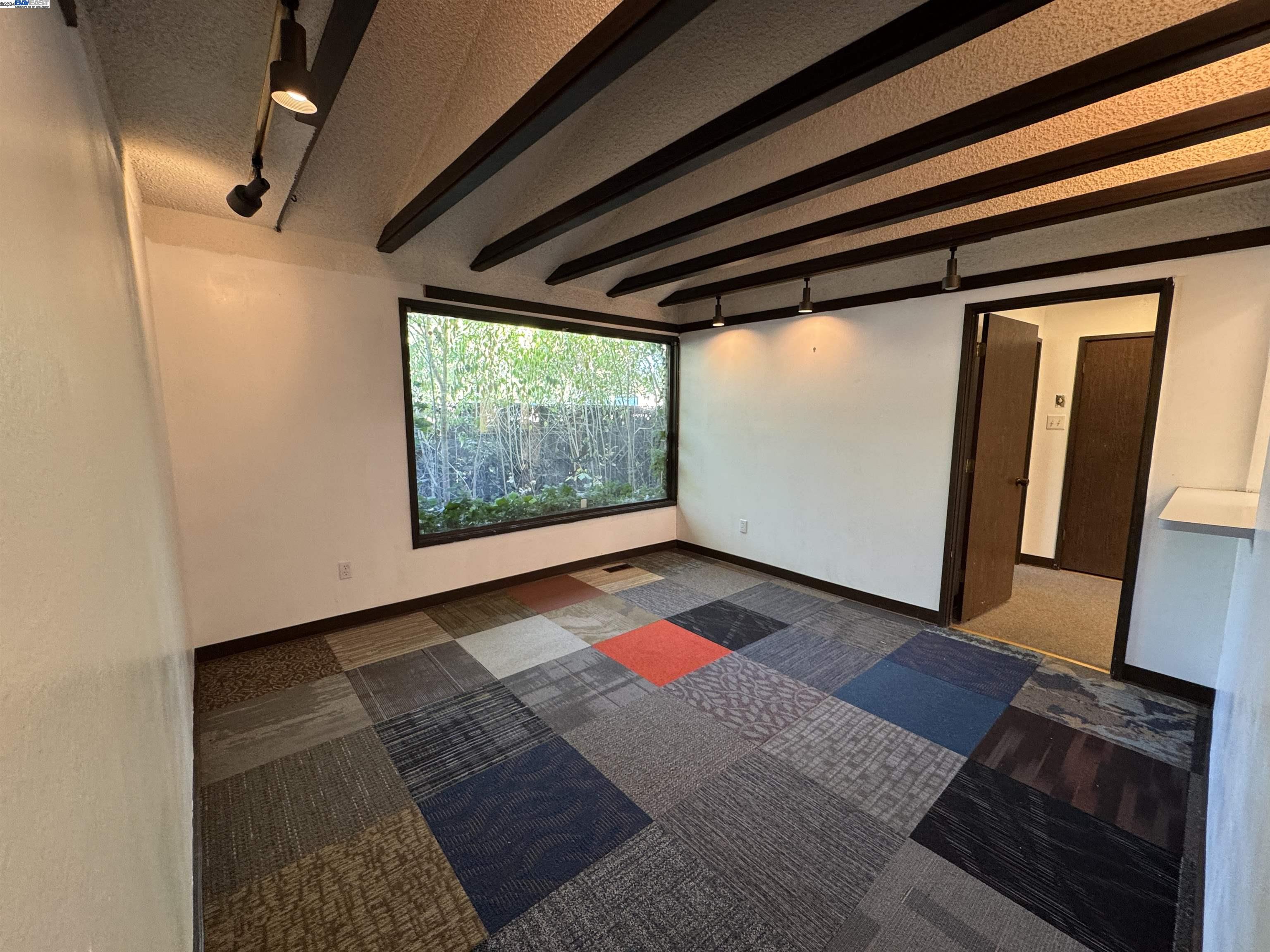 a view of an empty room with wooden floor and doors