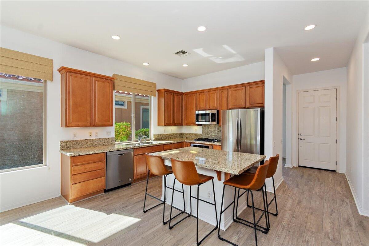 a kitchen with stainless steel appliances granite countertop a refrigerator and a stove top oven