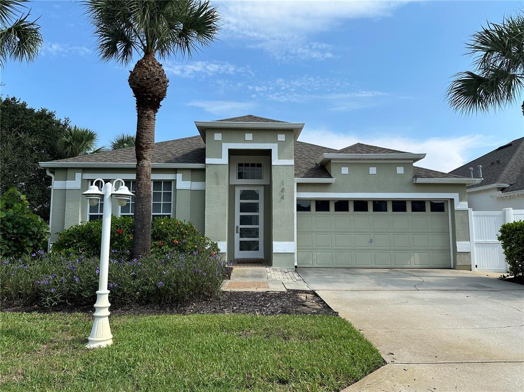 a front view of a house with a yard and palm tree