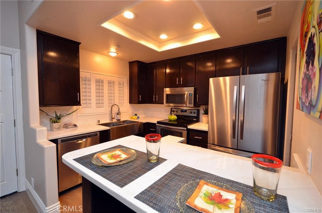 a kitchen with stainless steel appliances granite countertop a refrigerator and a stove top oven