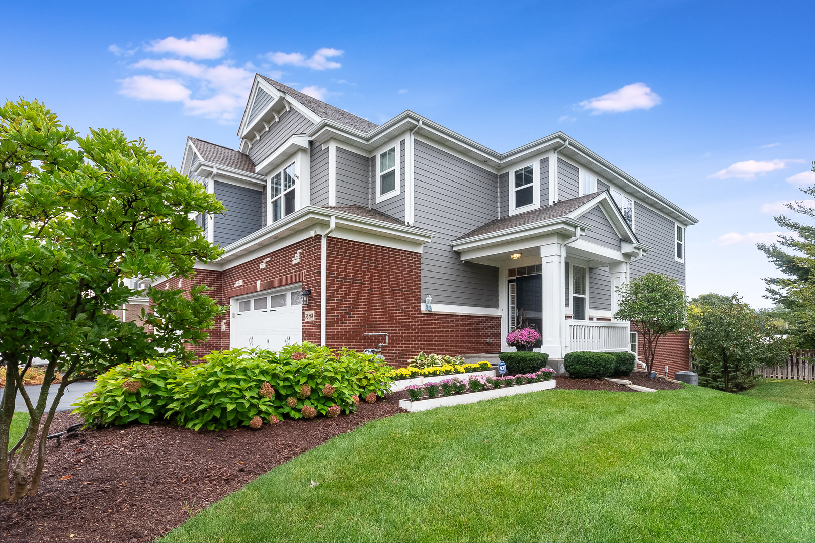 a front view of a house with a garden and plants