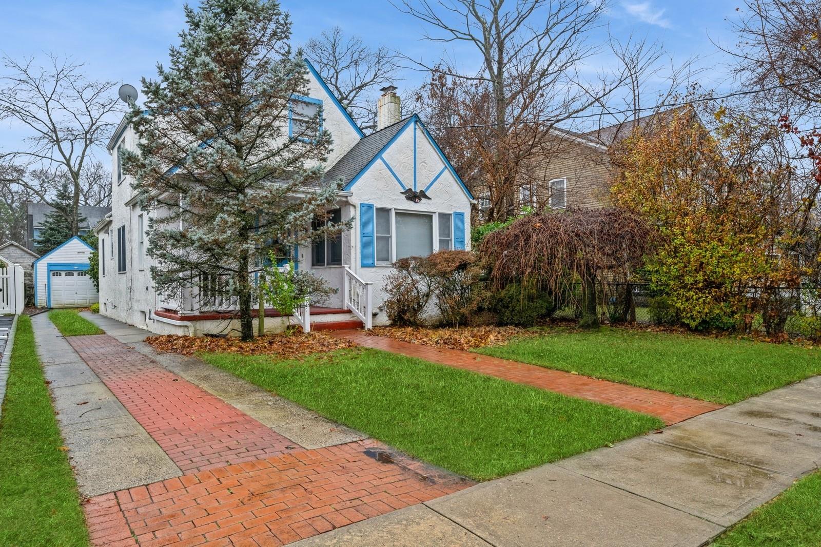 a view of a house with a yard and large tree