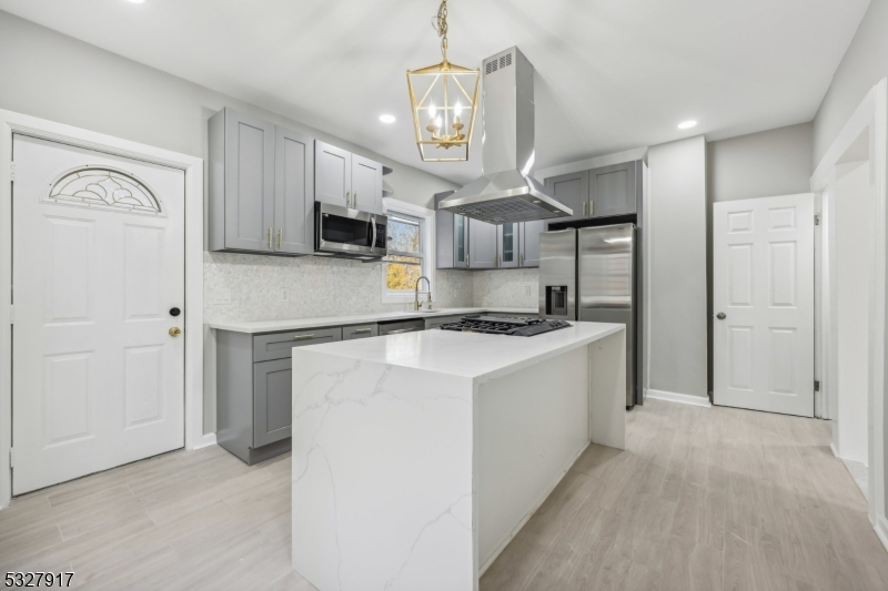 a kitchen with kitchen island a stove a sink and a refrigerator