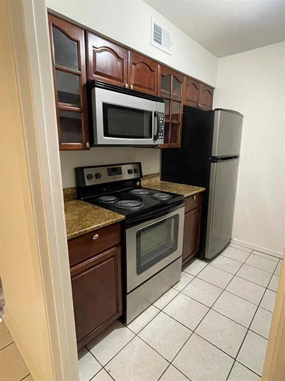 a kitchen with stainless steel appliances granite countertop a refrigerator stove and microwave