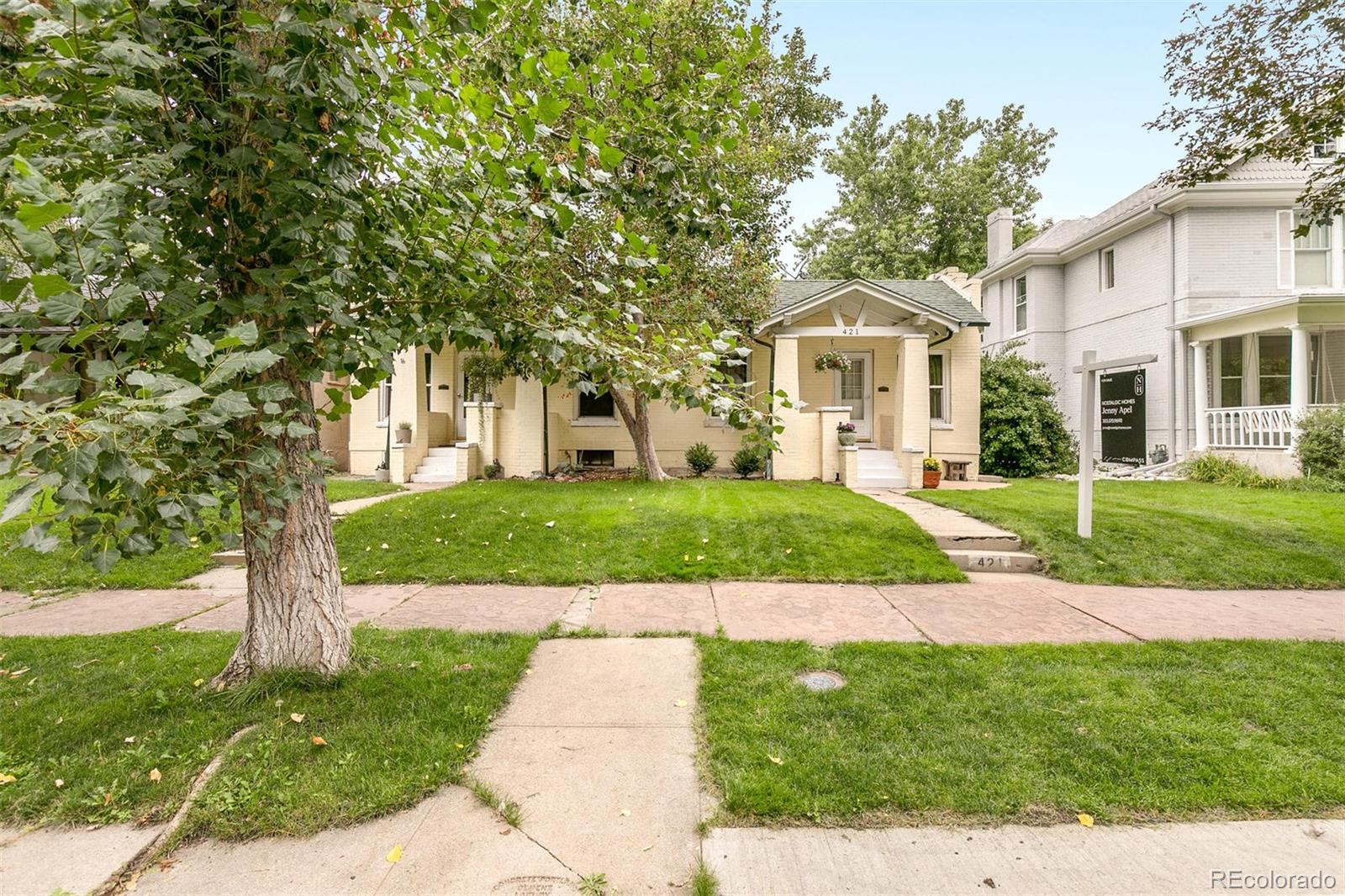 a front view of a house with a yard and trees